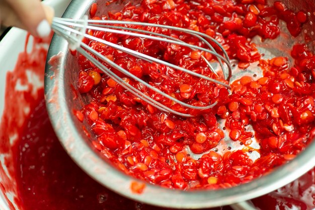 Making jam from viburnum berries concept Squeezing guelder rose berries for jam