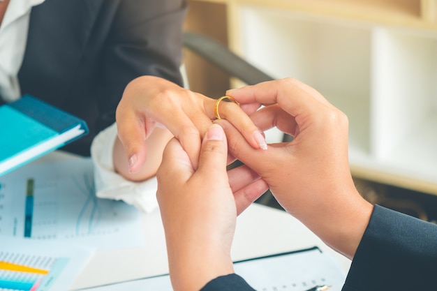 Making marriage proposal in office giving engagement ring to woman