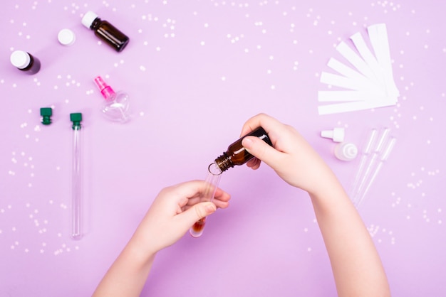 Making perfumes at home. Children's hands make perfume