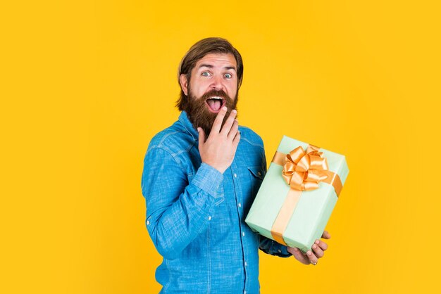 Making purchases at store buy anniversary gifts surprised male open box with something exciting inside mature man looking casual in surprise with present gift box commonly used for birthday