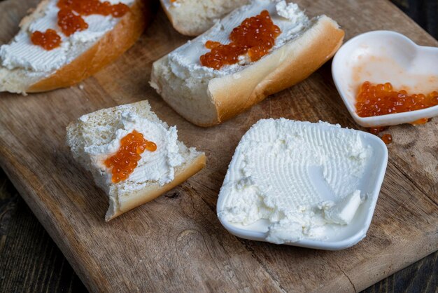 Making sandwiches with baguette and cream cheese with caviar