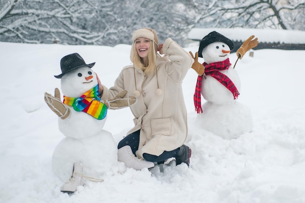 Making snowman and winter fun for people winter waman with snowman on snow background snowman and sn...