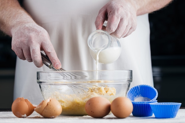 Making Sour Cream Lemon Cake. Pouring milk into glass bowl