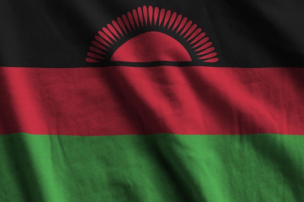 Malawi flag with big folds waving close up under the studio light indoors The official symbols and colors in banner