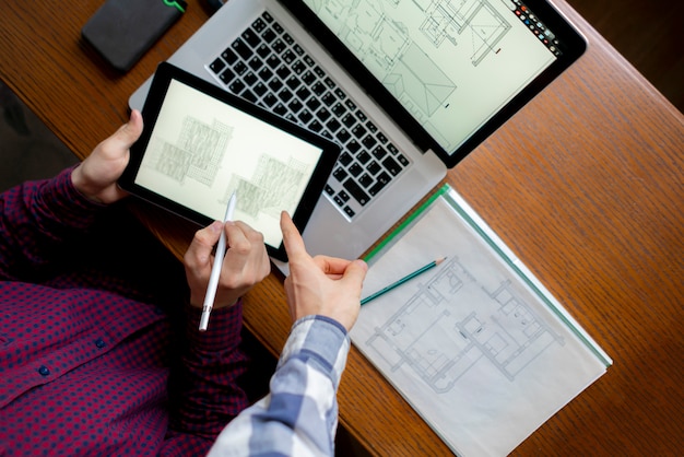 Male architect work with computer on wooden table