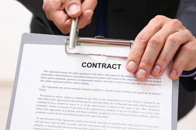 Male arm in suit offer contract form on