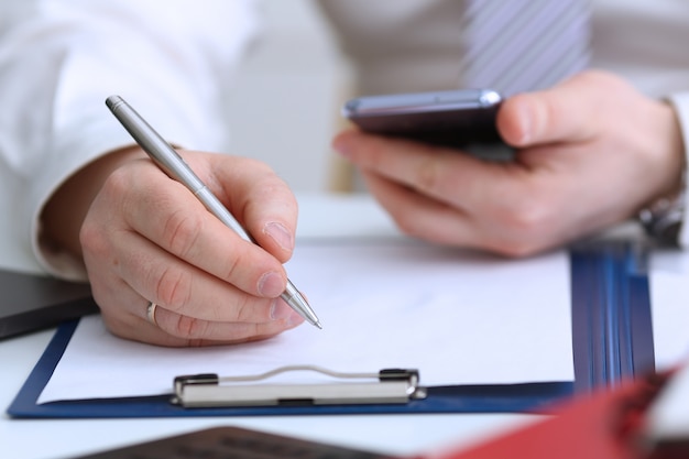 Male arm in suit and tie hold silver pen