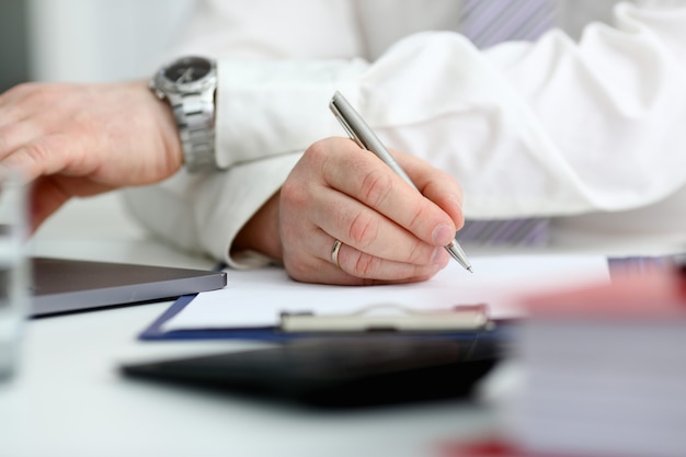 Male arm in suit and tie hold silver pen