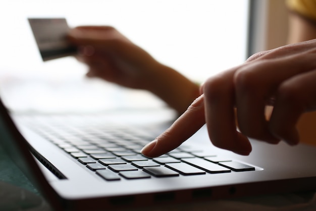 Male arms hold credit card press buttons