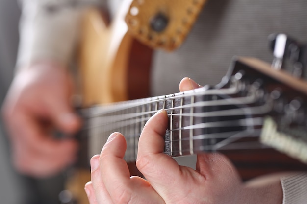 Male arms playing classic shape electric guitar