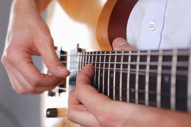 Male arms playing classic shape electric guitar