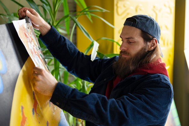 Photo male artist painting with watercolor in the studio