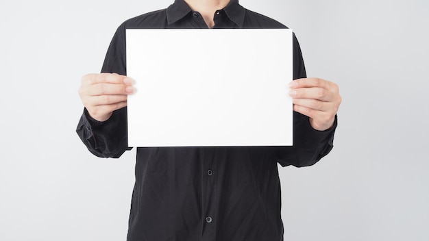 Male asian hold blank paper and wear black shirt on white background.