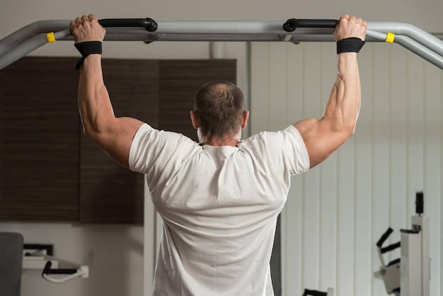 Male Athlete Doing Pull Ups  ChinUps In The Gym