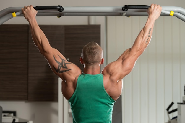 Male Athlete Doing Pull Ups  ChinUps In The Gym