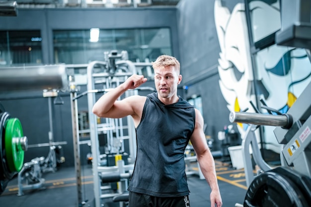 Male athlete exercising in the gym lifting weights pulling joints