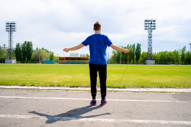 Male athlete sportsman practice with jump rope at the outdoor stadiums, increase stamina