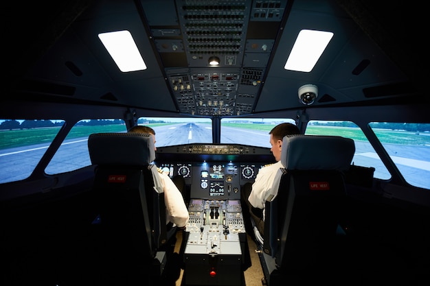 Male aviators checking airplane before flight