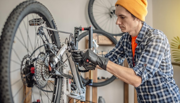 Photo a male bicycle mechanic repairs a mountain bike in a workshop