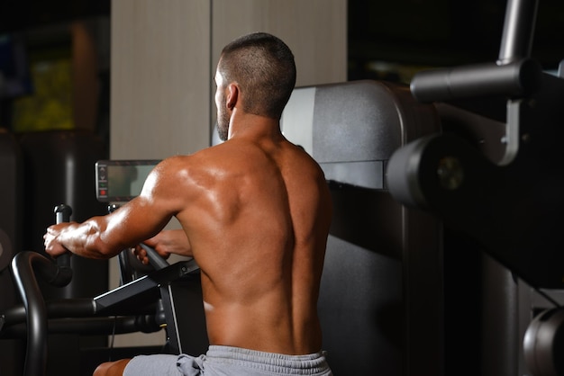 Male Bodybuilder Doing Heavy Weight Exercise For Back In Modern Gym