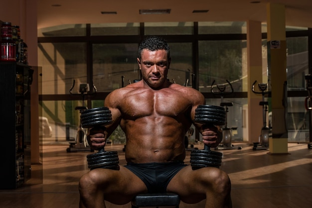 male bodybuilder resting after doing heavy weight exercise