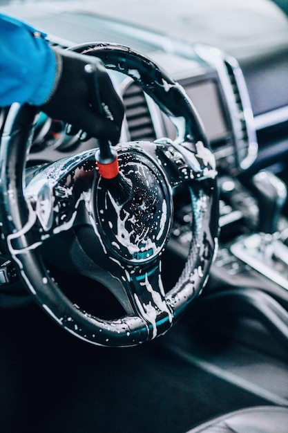 Photo male brushing rim of car steering wheel