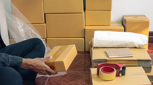 Male business owner working packing the order for shipping to customer packaging box for delivery