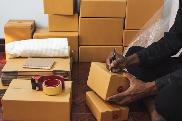 Male business owner working packing the order for shipping to customer packaging box for delivery