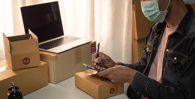 Male business owner working packing the order for shipping to customer packaging box for delivery