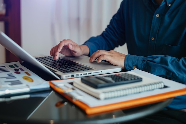 Male businessman and financial concepts about office work Analysts discuss business with laptop and calculator as a tool