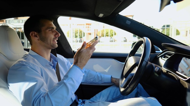 Photo male businessperson have serious telephone conversation while riding an autonomous self driving electric car nervous businessman talks by smartphone during riding on electrical auto with autopilot