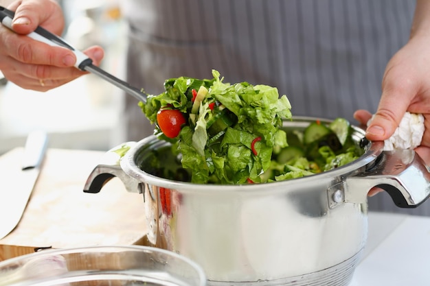 Male chef prepares fresh detox healthy salad on table