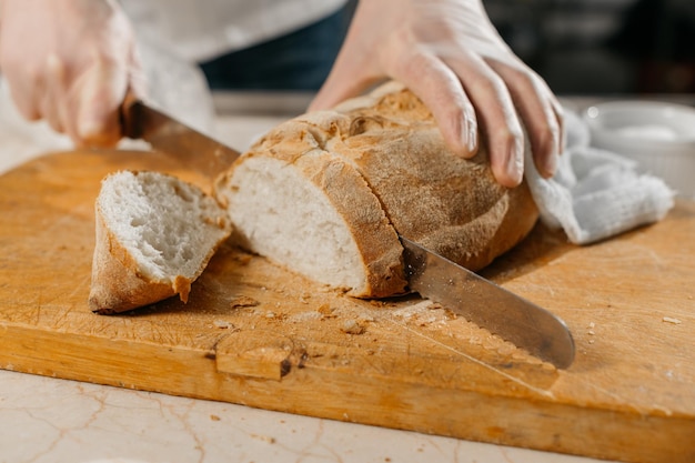 Male chef's hands cut bread. High quality photo