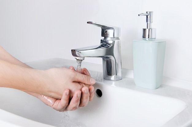 Male cleaning hands. Washing hands with soap to protect from virus