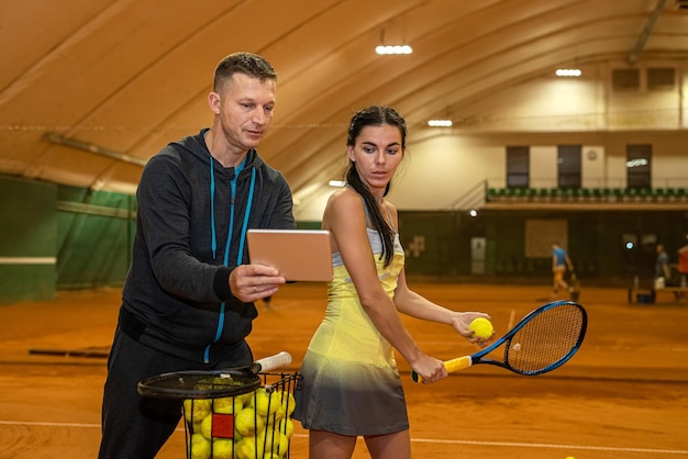 Male coach records the successes of his tennis player in a journal