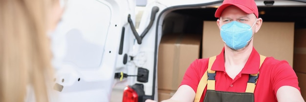 Male courier in face mask give receiver order in cardboard