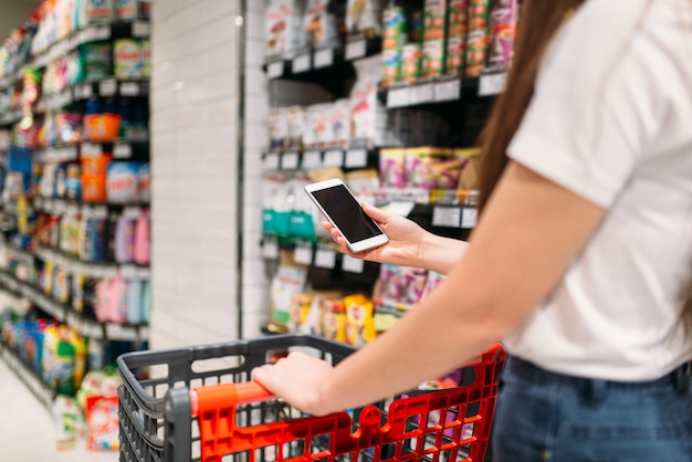 Male customer uses mobile phone in supermarket