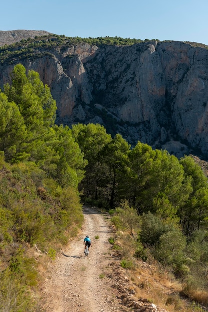 A male cyclist in a gravel road bicycle ride in the  mountains of Costa Blanca, Alicante, Spain