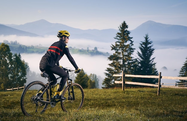 Male cyclist riding bicycle in mountains