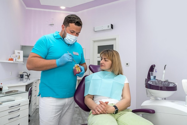 Male dentist explains the plan for further dental treatment to female patient in the clinic