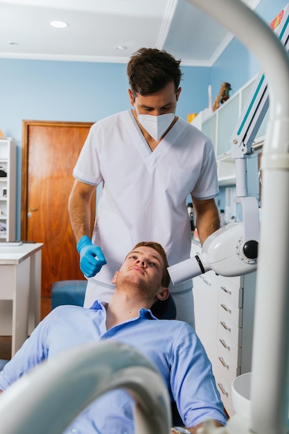 Male dentist takes jaw x-ray of patient.