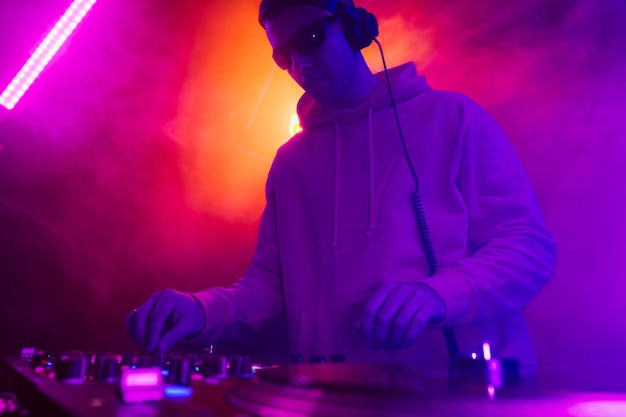 Male dj playing music in the night club