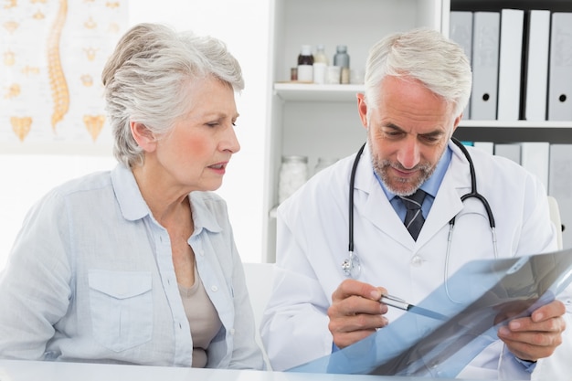 Male doctor explaining x-ray report to senior patient