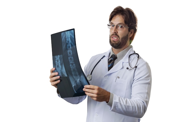 Male doctor looking at a x-Ray on a White wall