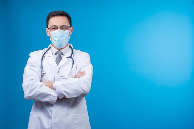 Male doctor in mask looking at camera in studio