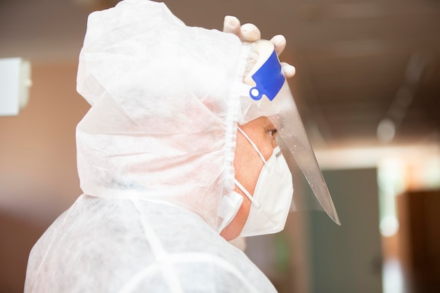 Male Doctor in a protective mask and suit in profile for coronavirus infection