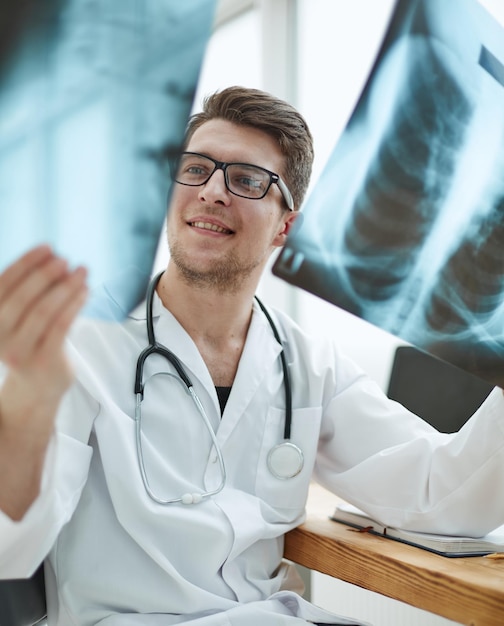 Male doctor radiologist examines xrays in a medical office