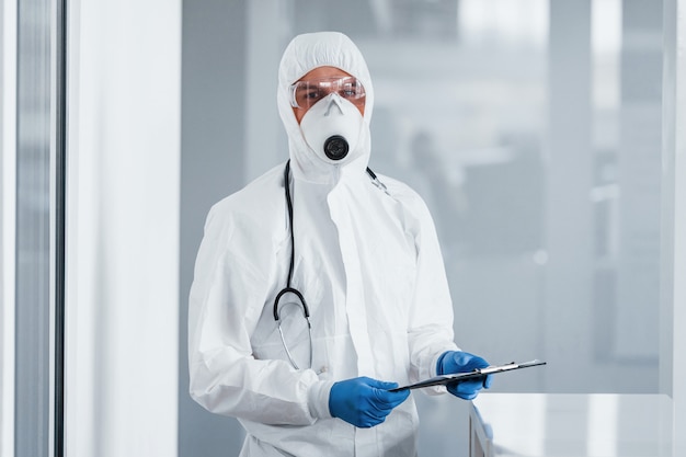 Male doctor scientist in lab coat, defensive eyewear and mask