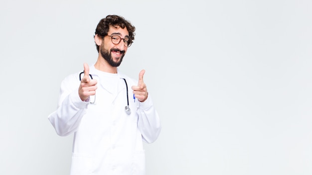 male doctor smiling with a positive, successful, happy attitude pointing, making gun sign with hands