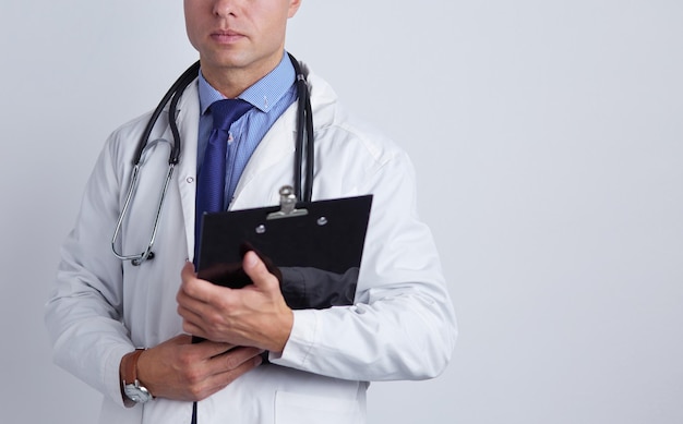 Male doctor standing with folder isolated on white background